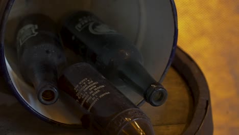 slow reveal of old bottles in a bucket