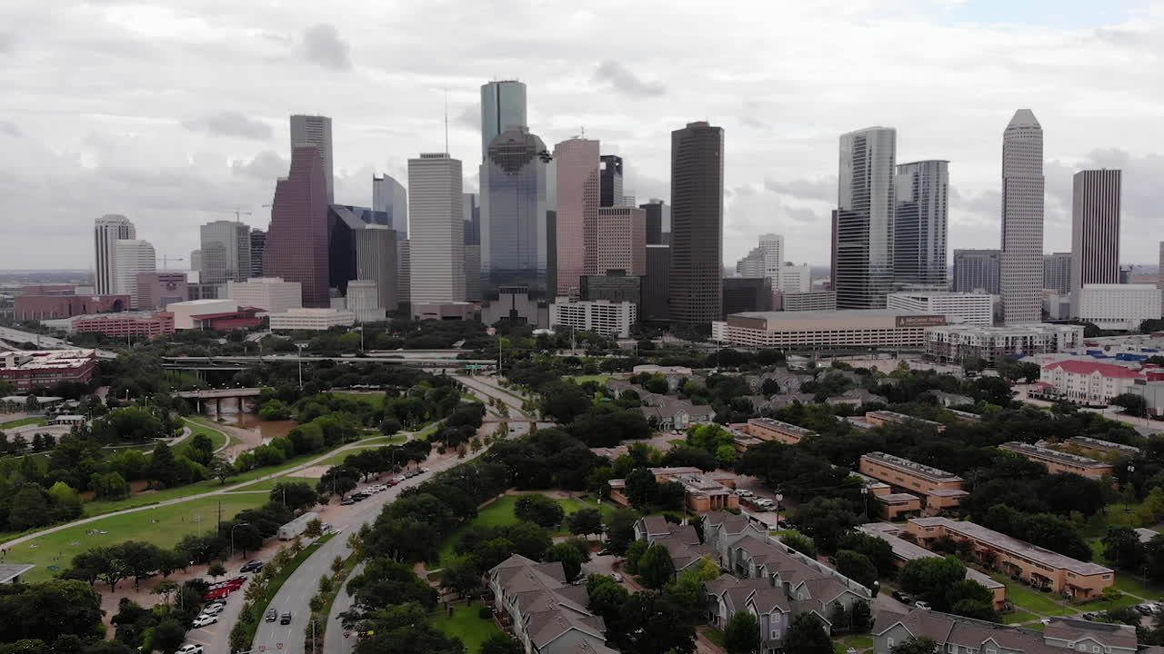 Auto sull'autostrada davanti allo skyline di Houston in una giornata nuvolosa.