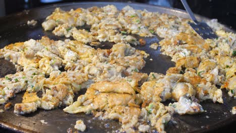 Chef-is-cooking-fried-mussels-omelet-on-hot-pan