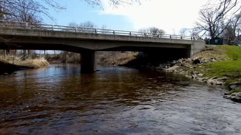 Aerial-fly-over-the-creek-in-a-small-American-town-in-spring---fast-dolly-shot