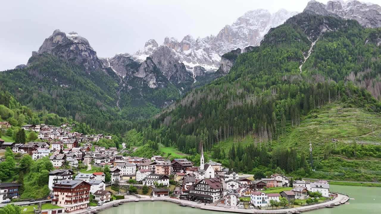 Alleghe drone shot showing lake, forest, and mountain range in a cinematic circle motion
