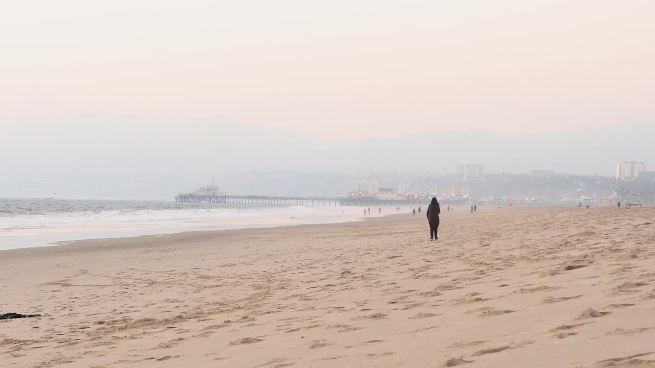 Woman walking on the sand at Santa Monica beach California