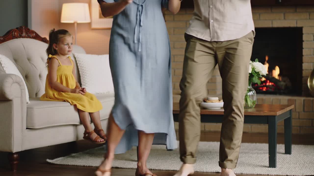 Stepping sequence-starting, couple swaying at home for child on sofa, in blue dress and khaki pants