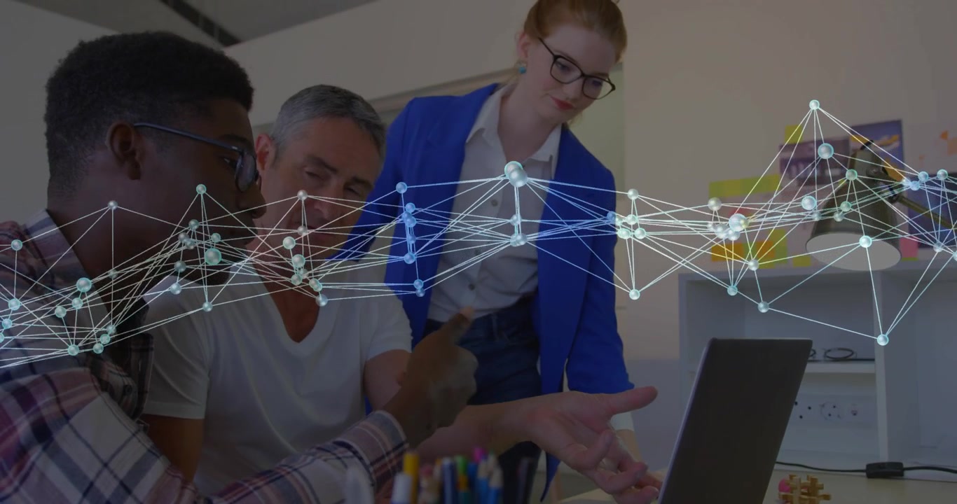 Plaid man pointing at laptop starting review, team leaning, network overlay showing business data
