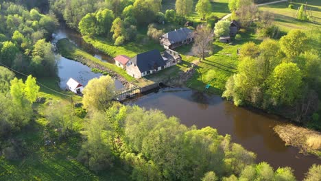 small dam controls flow of water in countryside, aerial parallax orbit