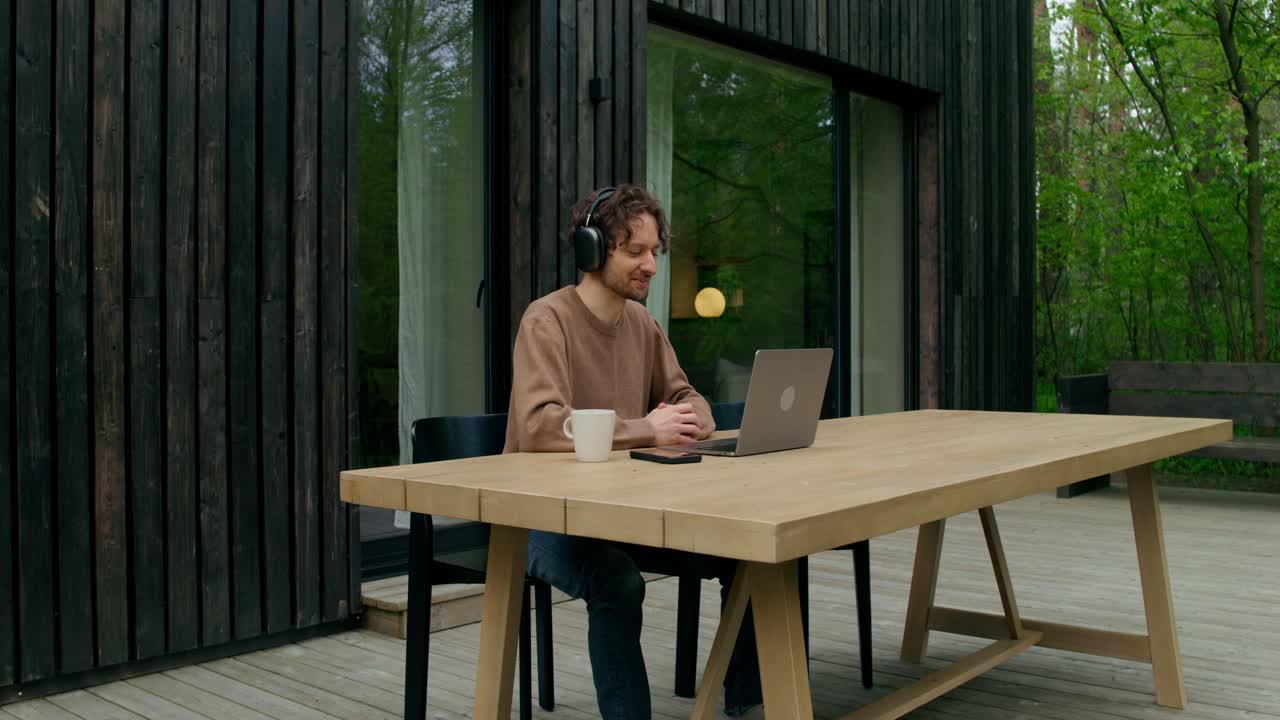 Mies videopuhelussa ulkona terassilla
