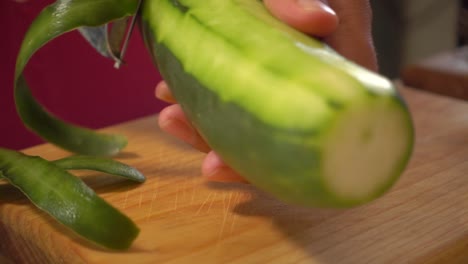 pelar un pepino en una tabla de cortar