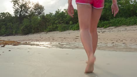 woman in swimsuit walking on tropical white sand beach and stream in evening 4k