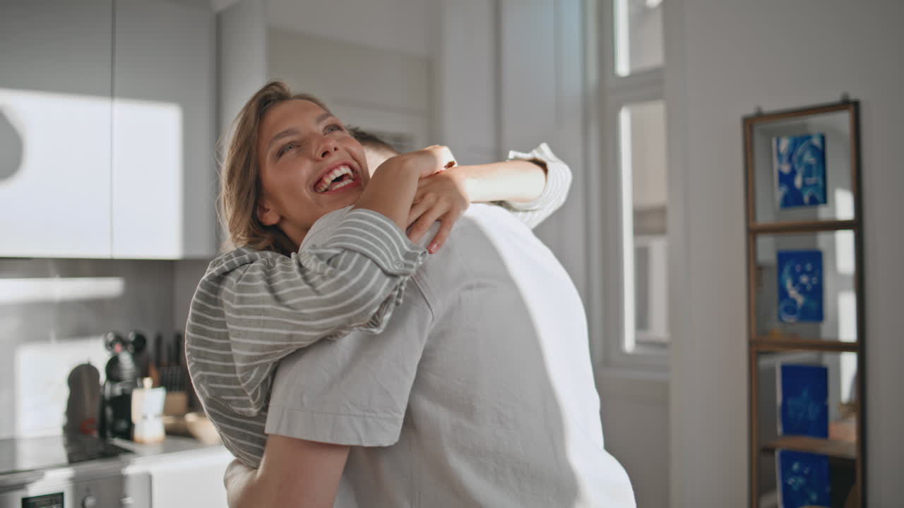 Cheerful woman hugging man in cozy home closeup. Happy couple celebrating deal