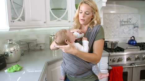 Busy-Mother-With-Baby-In-Sling-At-Home,-Slow-Motion