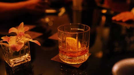 whisky glass and flowers on a bar table