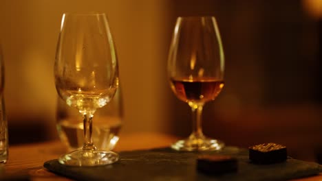 hand reaching for whisky glass in distillery