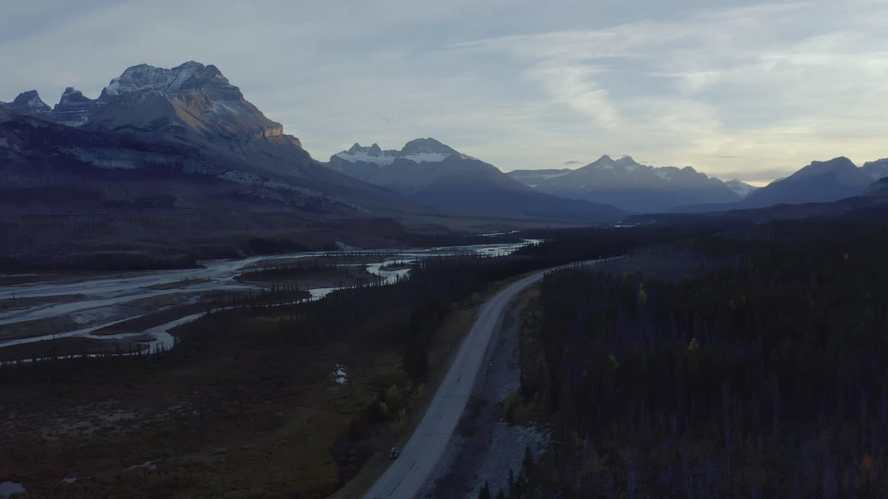 los picos de las montañas rocosas se elevan por encima de la carretera a través del valle del río, alberta, canadá