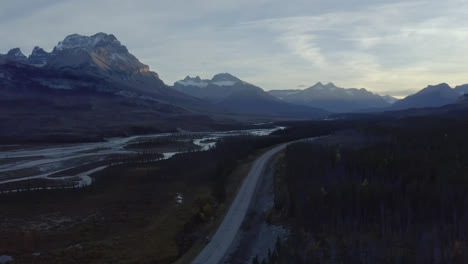 Los-Picos-De-Las-Montañas-Rocosas-Se-Elevan-Por-Encima-De-La-Carretera-A-Través-Del-Valle-Del-Río,-Alberta,-Canadá