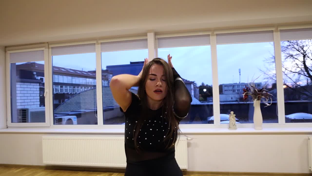 전문적이고 열정적인 여성 댄서가 댄스 플로어 슬로우 모션에서 춤을 춥니다