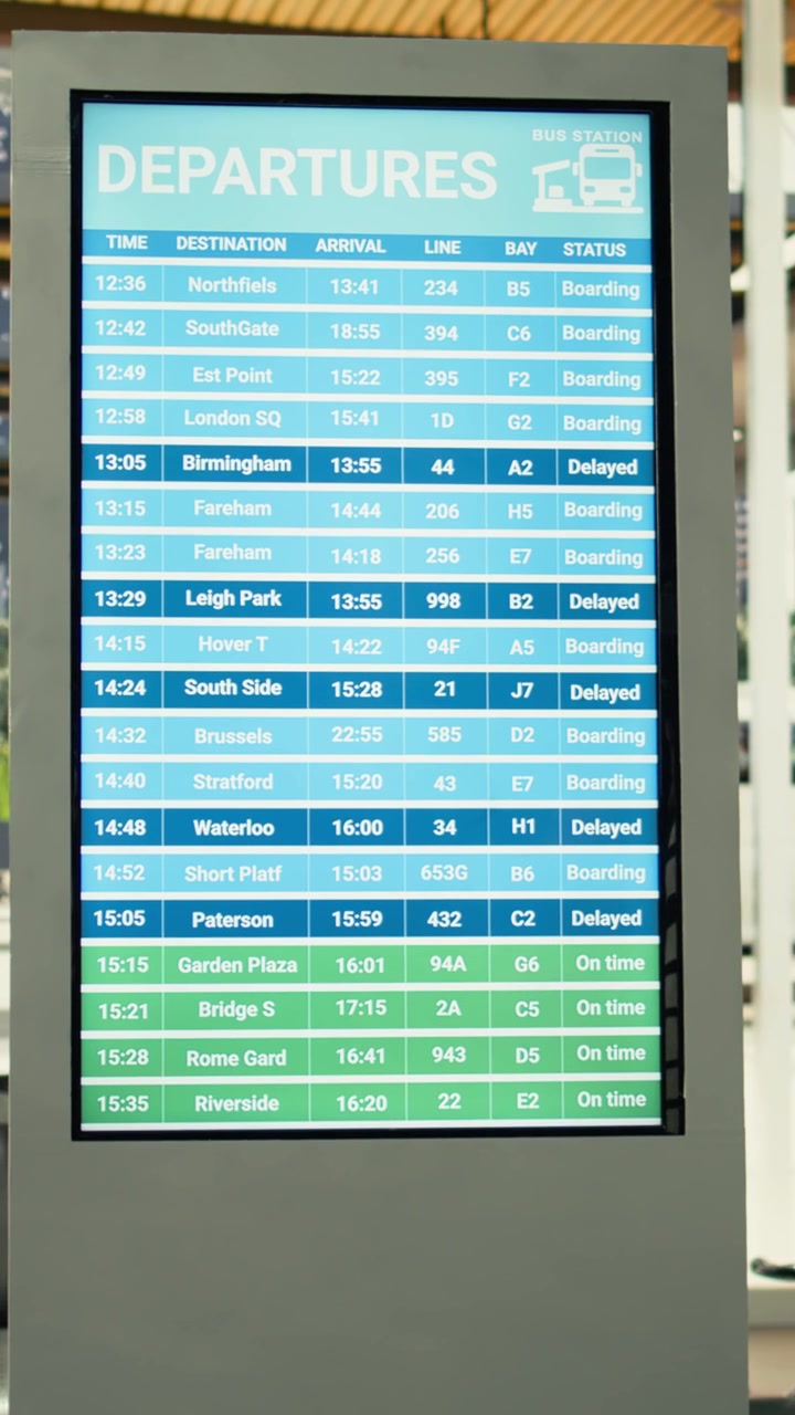 Black commuter gathers near information board in busy city bus station