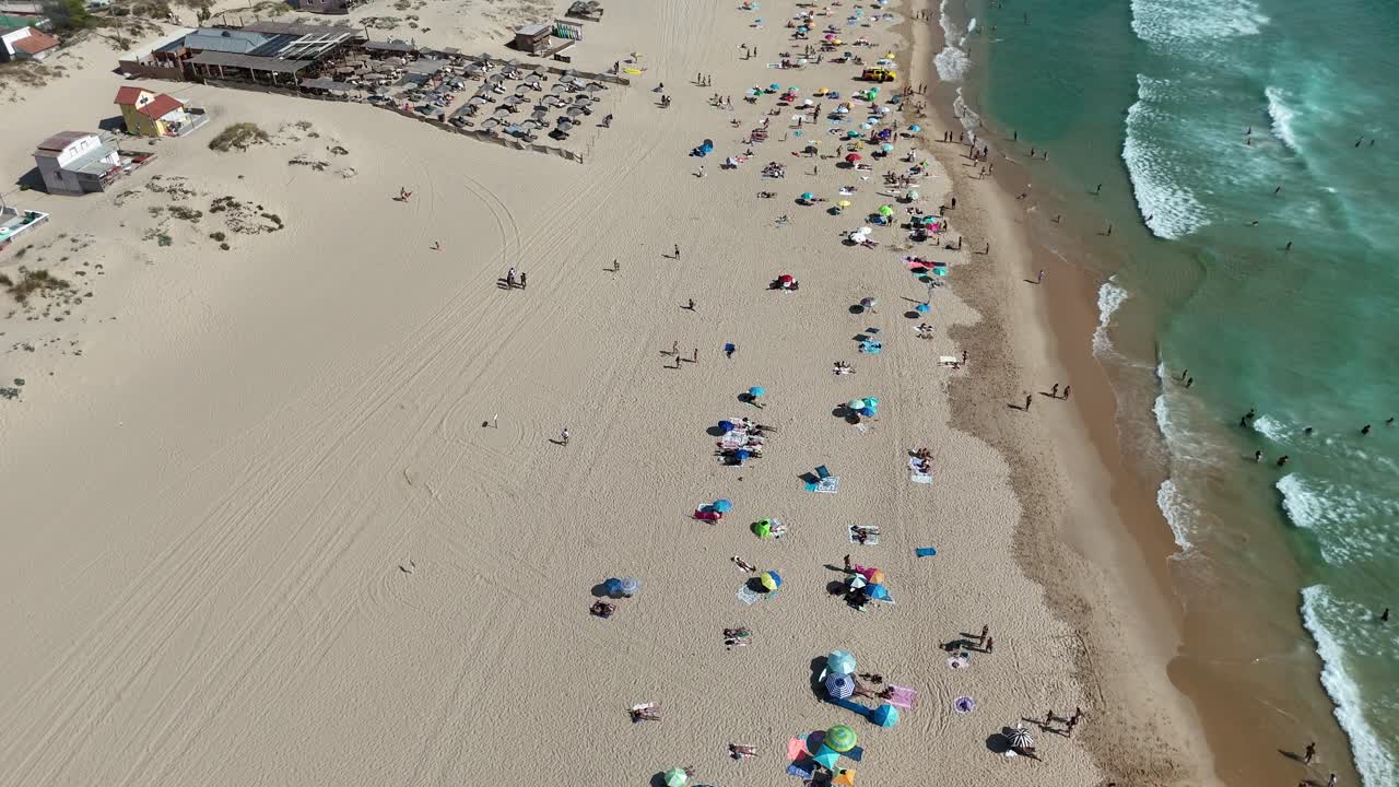 Aerial view of a beach with people and parasols