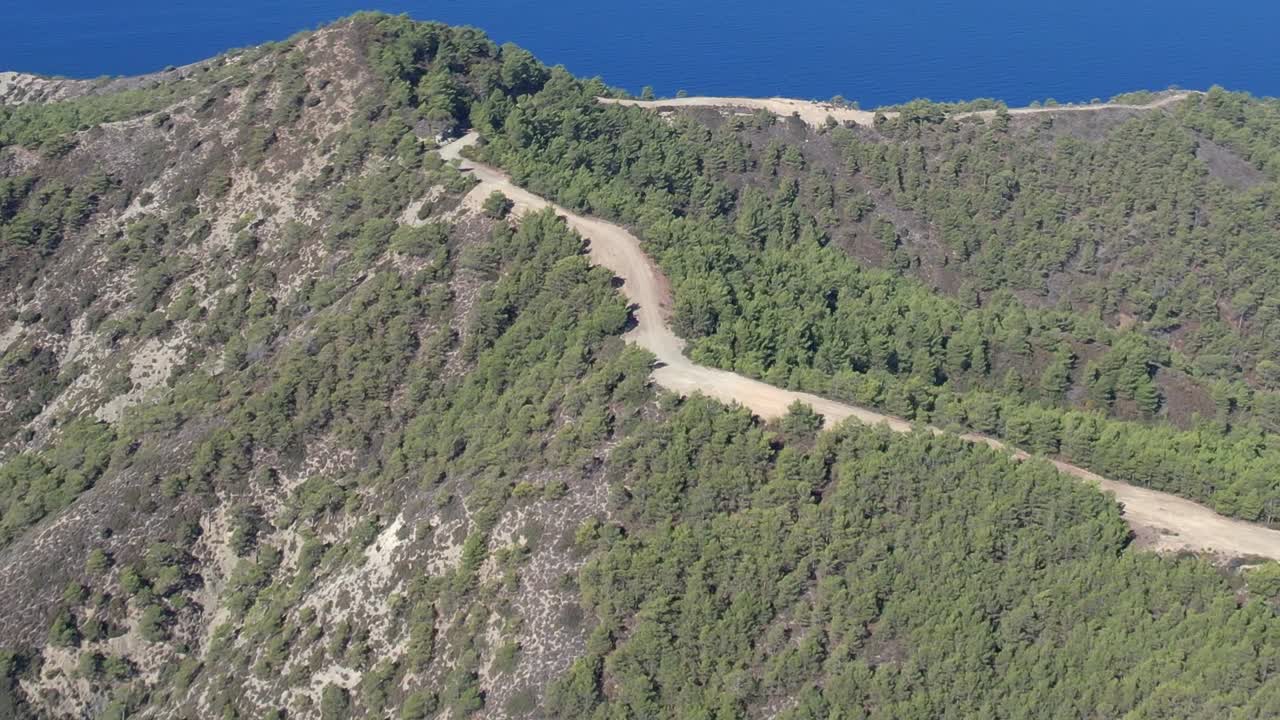 Aerial view of lush greenery and winding road in Greece