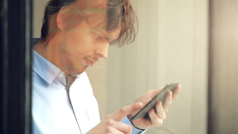 man-using-tablet-computer-touchscreen-in-cafe