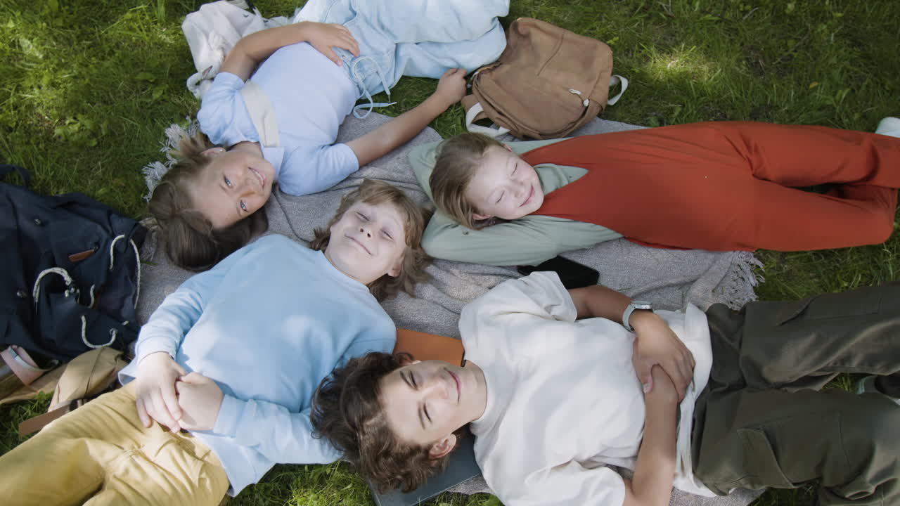 Group of Friends Relaxing on a Blanket in the Park