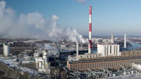 aerial view of a smoking heat and power plant next to the vistula river in warsaw, poland