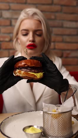 woman eating a dripping burger at a restaurant