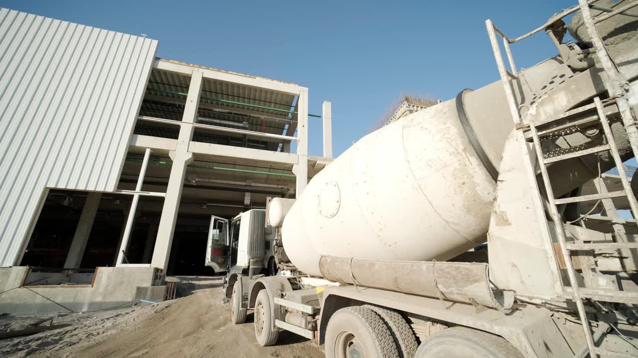el mezclador de hormigón en la planta industrial. los constructores están construyendo una fábrica, un hangar.