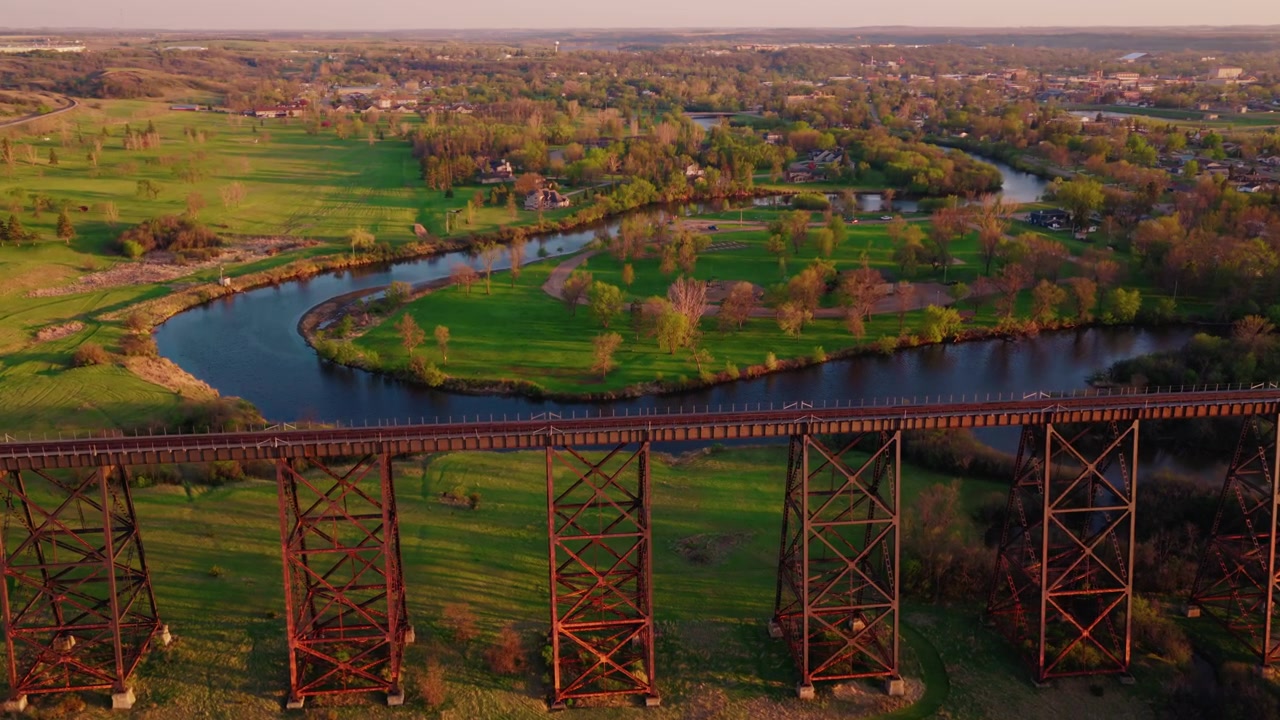 Togskinner forsvinder i horisonten over Sheyenne-floden og den lille by Valley City, North Dakota. Hi-Line Jernbanebro