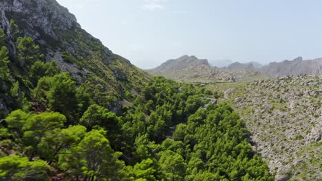 Aerial-view-of-the-two-different-sides-of-a-mountain-range,-forested-and-stony-dry