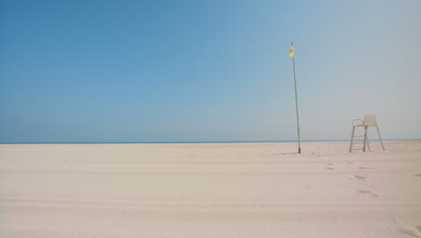 empty beach with lifeguard chair and flag