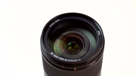 black photo lens rotates on a white background. view from above