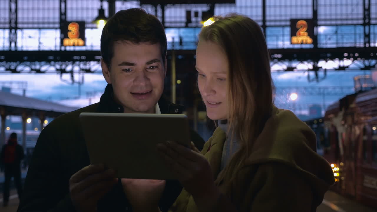 저녁에 역에서 패드를 사용하는 젊은이들
