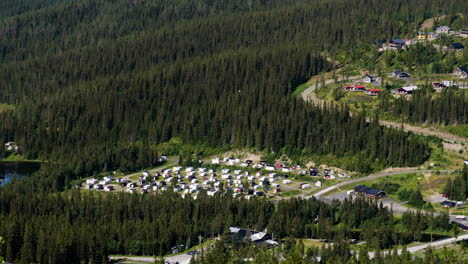 a scenic landscape of dense forest with a ski cabin resort in sweden during summer