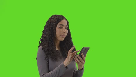 foto de perfil de una mujer desplazándose y usando un teléfono móvil contra una pantalla verde