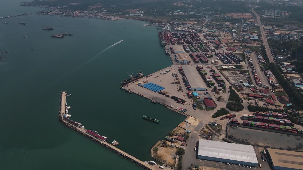 grandes áreas industriales donde se apilan grandes cantidades de contenedores en la gran terminal de contenedores de sihanoukville con barcos junto a camboya