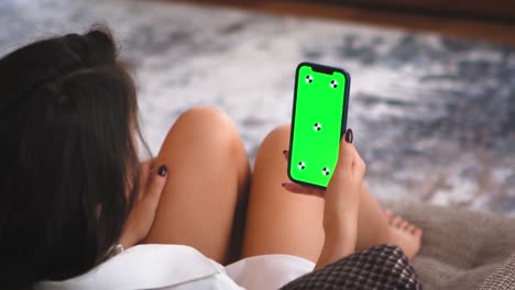 green screen, chroma key of phone. greenscreen of chromakey mockup, tracking markers. girl watching content on cellphone