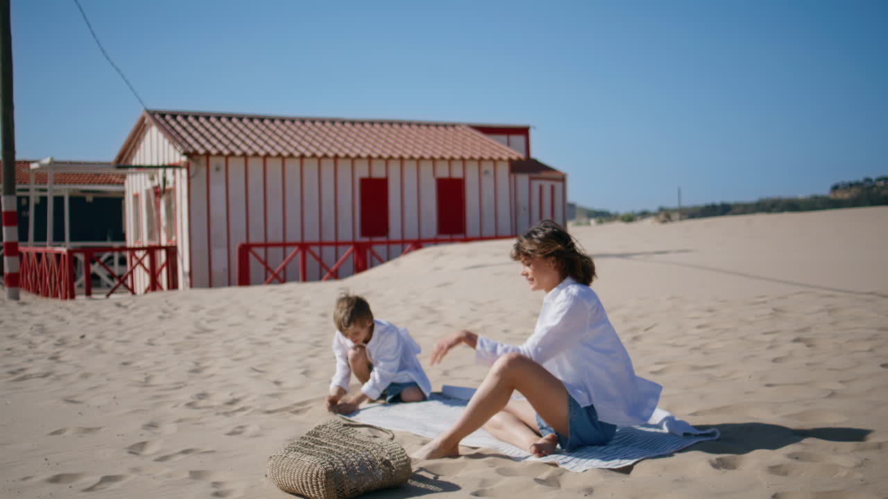 Family preparing picnic place on sandy beach spending sunny weekend together