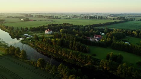 Villa-Mit-Boot,-Umgeben-Von-Grünen-Feldern-Entlang-Des-Flusses-Im-Grünen