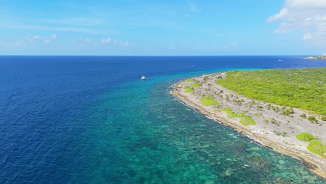 panoramic aerial overview push in to dive boat anchored near stunning beautiful reef in curacao