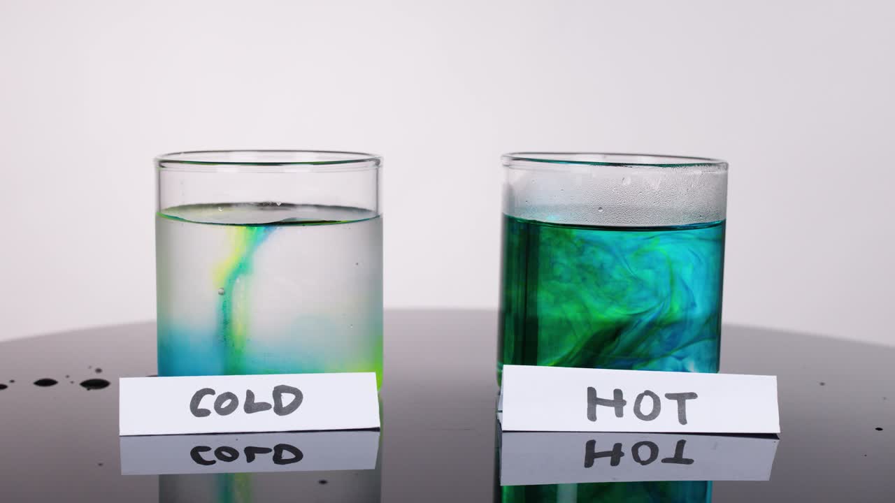 Food coloring disperses faster in hot water than cold, under bright, even studio lighting