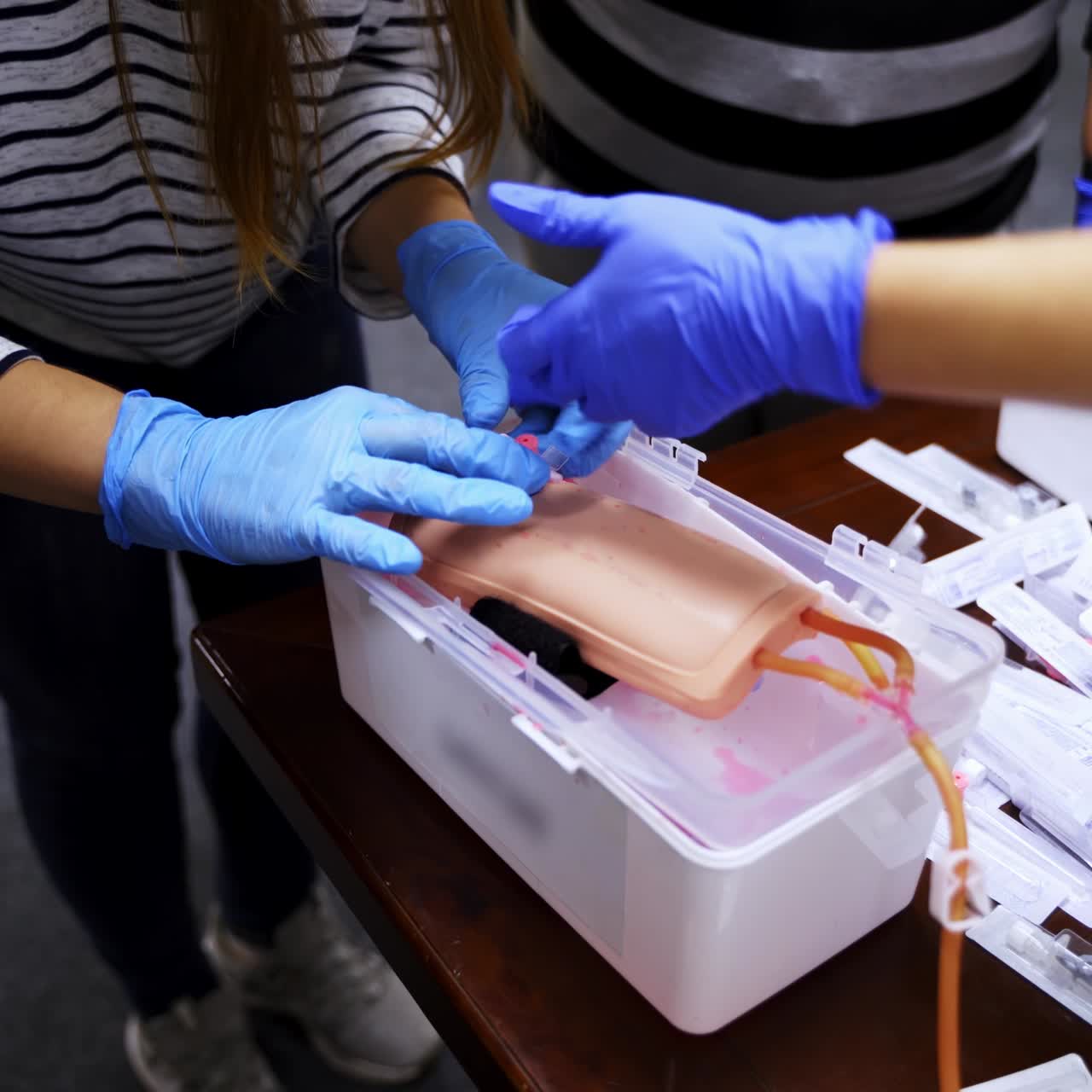 Training injection into a vein on a mannequin arm. Student studying how to put dropper in a training center. Medical practice