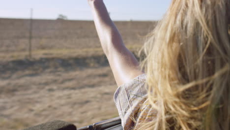 hermosa amiga rubia disfrutando de un viaje en coche descapotable vintage