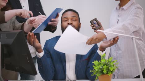 un joven empresario tranquilo medita en una reunión de negocios evitando la presión de colegas molestos y enojados.