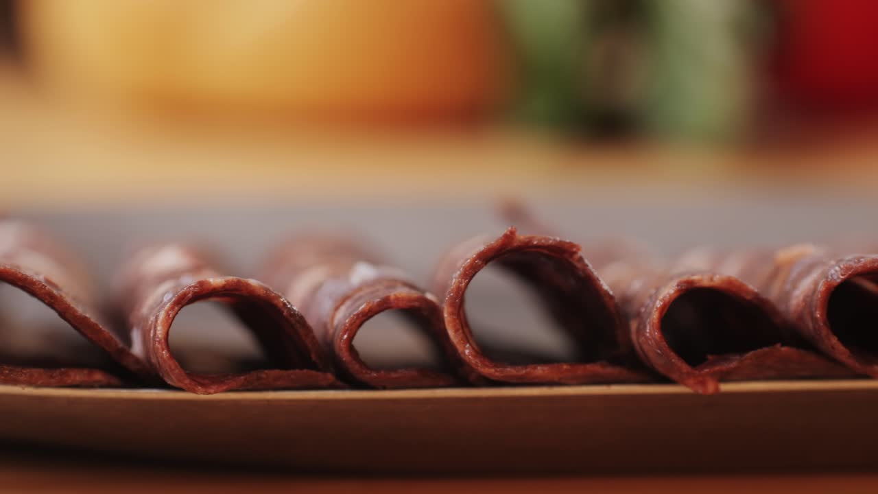 black bull sausage ham, tongue pork dry-cured sausage on a black background, traditional spanish delicatessen food, close up.