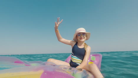 Ein-Mädchen-Mit-Hut-Und-Sonnenbrille-Schwimmt-Im-Meer-Auf-Einer-Aufblasbaren-Matratze-Frohes-Urlaubskonzept