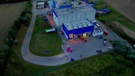 firefighters brigade with fire trucks in waste incineration plant - aerial drone shot