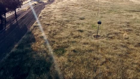 slow motion aerial view of alentejo - portugal: rustic beauty of wheat bales and stork nests in the golden fields