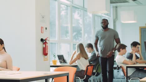 african man coming in coworking space. closeup serious man opening laptop.