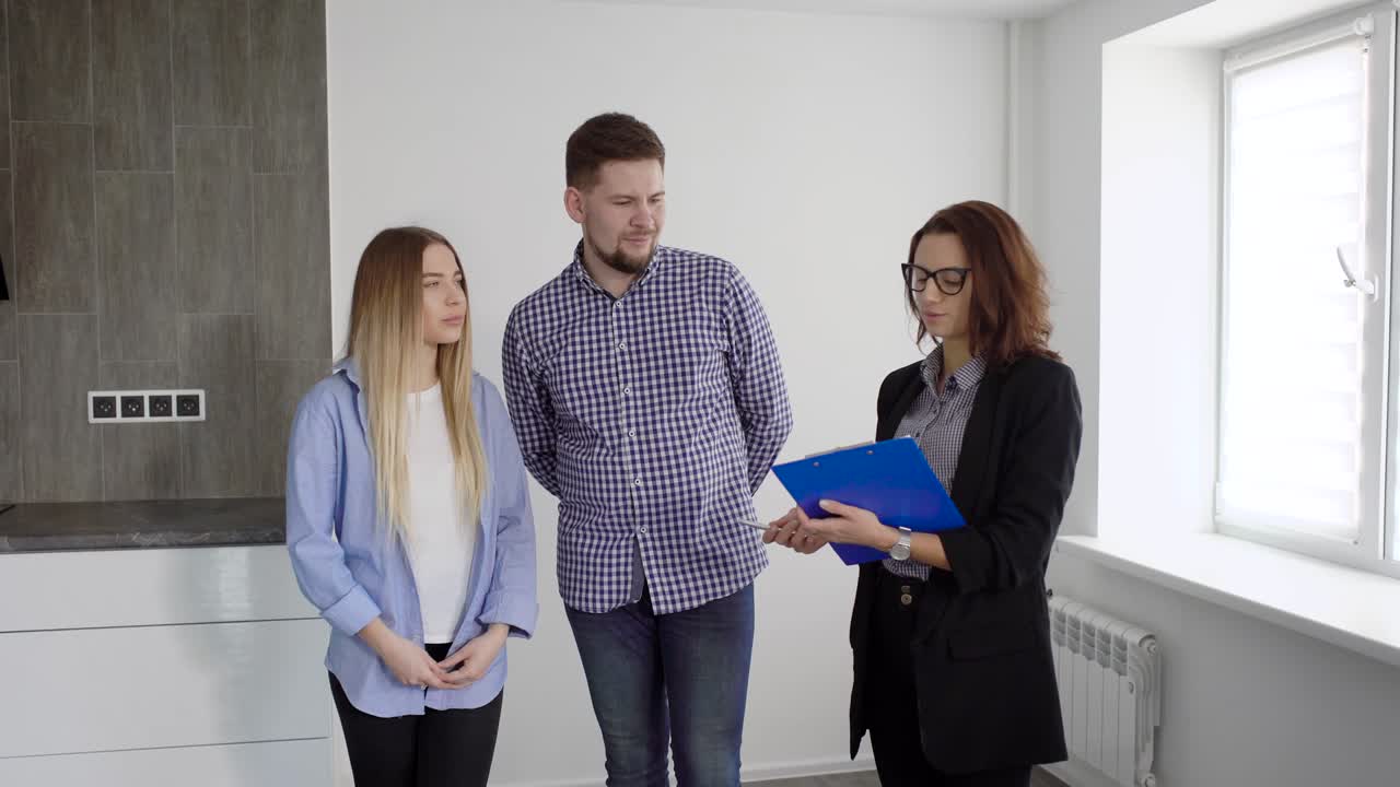 familia de dos y agente de bienes raíces discutiendo contrato interior