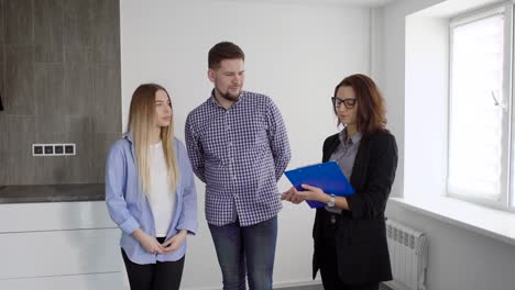 family of two and real estate agent discussing contract indoor